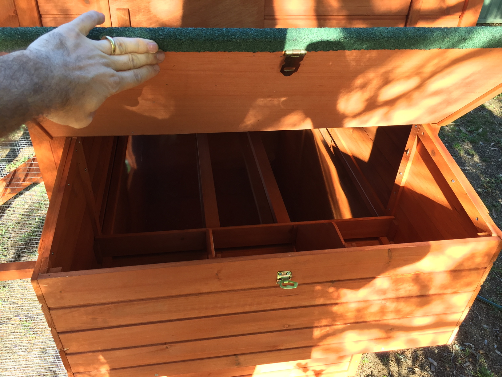 Nesting boxes with egg-collection hatch. The nesting boxes are now filled with a thick layer of wood shavings.