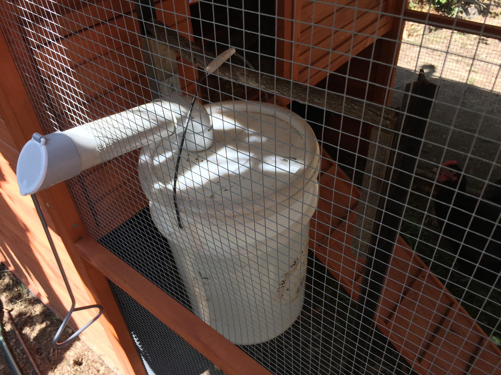 This is how you fill the water bucket from outside the cage. Lift the flap. Insert hose. Just like filling a car.