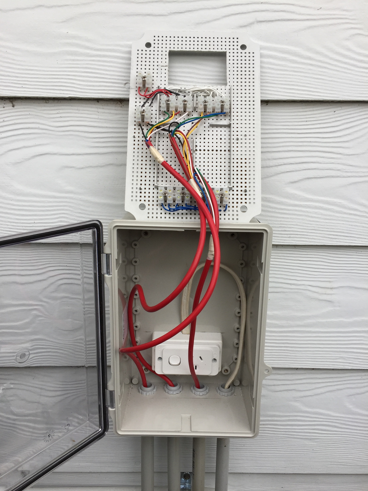 Enclosure mounted outside near my electrical box with the panel flipped and sitting above the enclosure