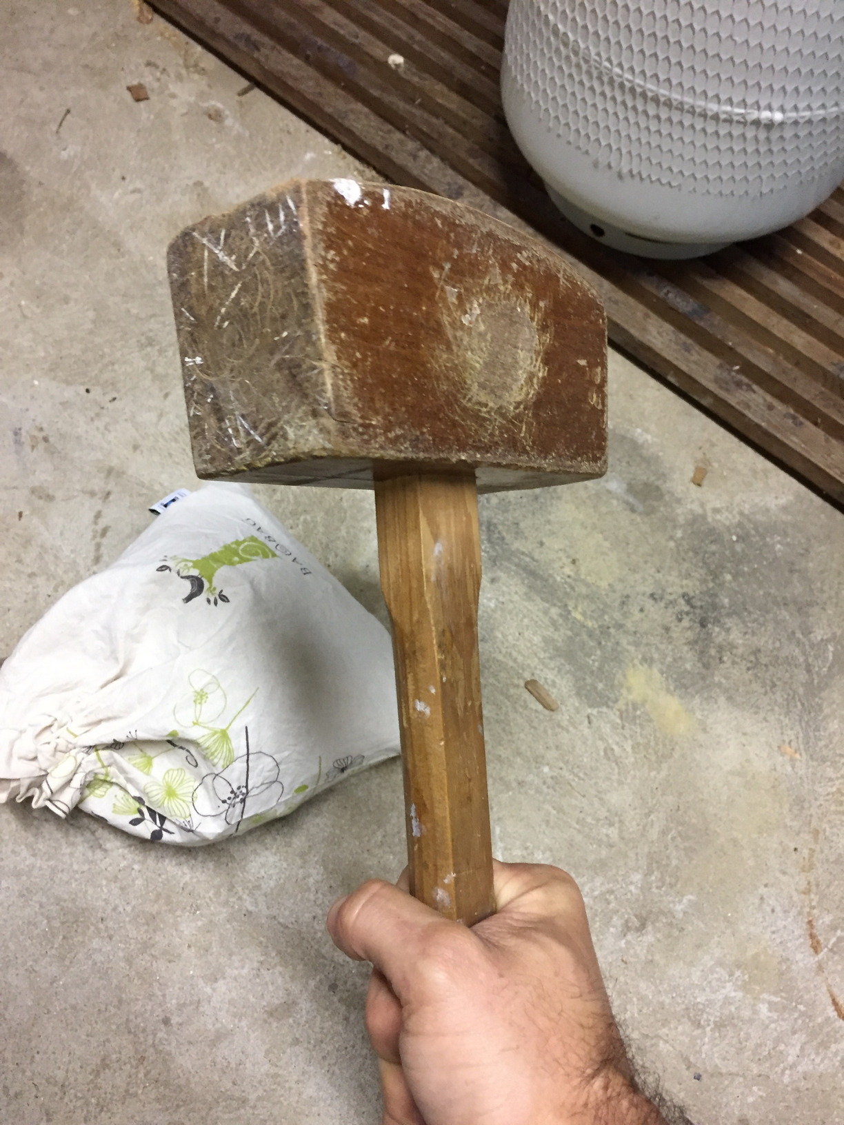 This is me trying to gently coax the wheat berries out of their husks with a wooden mallet.